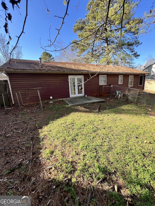 back of property with a yard, a patio area, and french doors