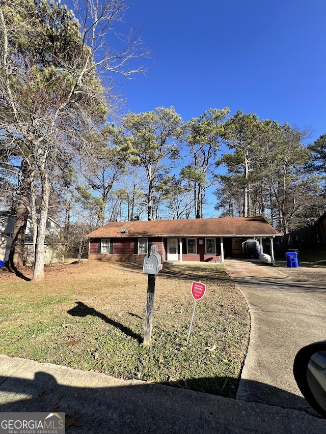 ranch-style house featuring a front lawn and a carport