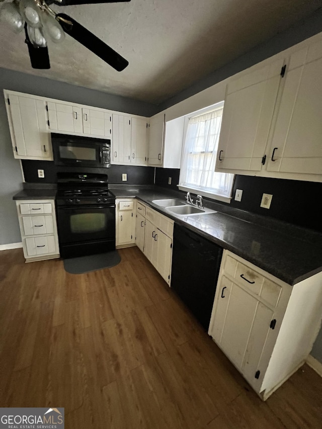 kitchen featuring dark wood-type flooring, black appliances, white cabinets, sink, and ceiling fan