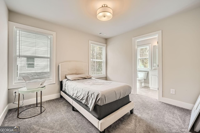 carpeted bedroom with multiple windows and ensuite bathroom