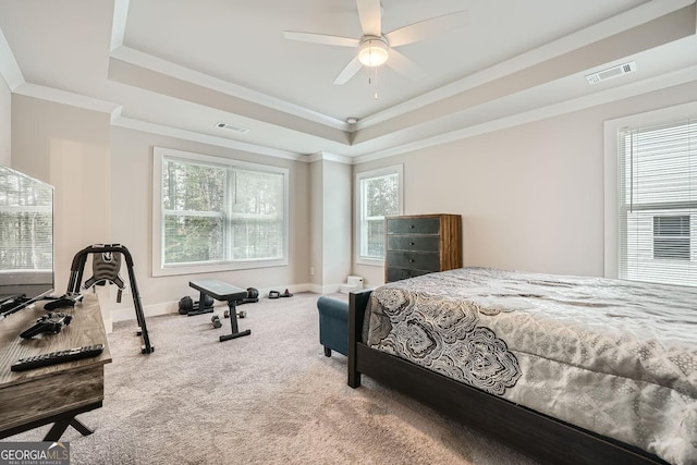 bedroom featuring carpet floors, a tray ceiling, ceiling fan, and ornamental molding