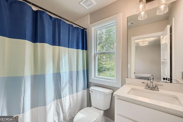 bathroom with vanity, toilet, plenty of natural light, and curtained shower