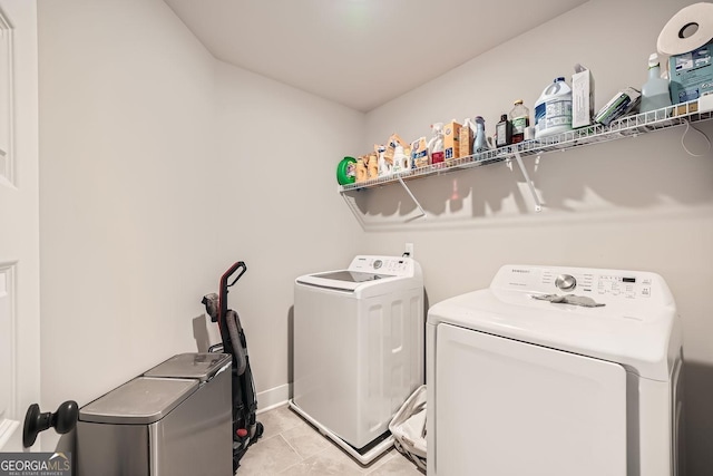 clothes washing area with light tile patterned floors and separate washer and dryer