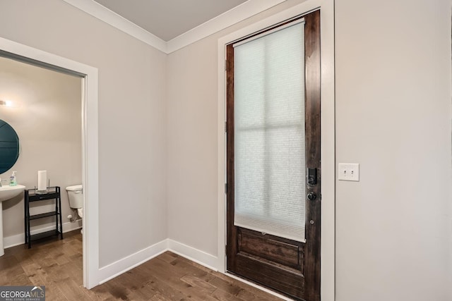 entrance foyer with ornamental molding and hardwood / wood-style flooring