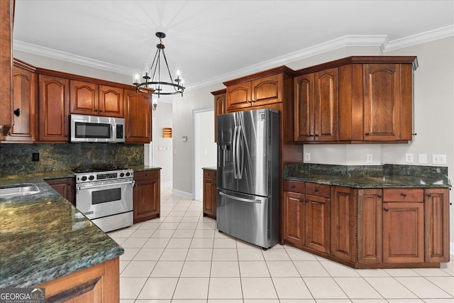 kitchen featuring a notable chandelier, backsplash, pendant lighting, appliances with stainless steel finishes, and ornamental molding