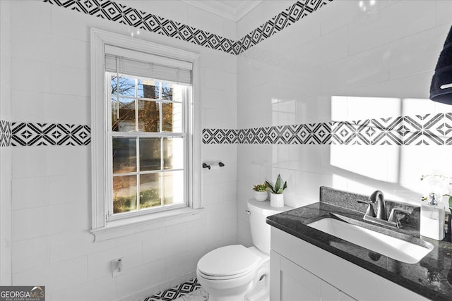 bathroom with vanity, tile walls, and toilet