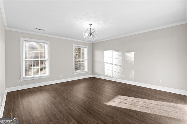 spare room with wood-type flooring, ornamental molding, and an inviting chandelier