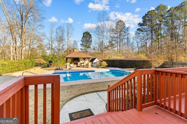 view of pool with a diving board, a patio area, and a wooden deck