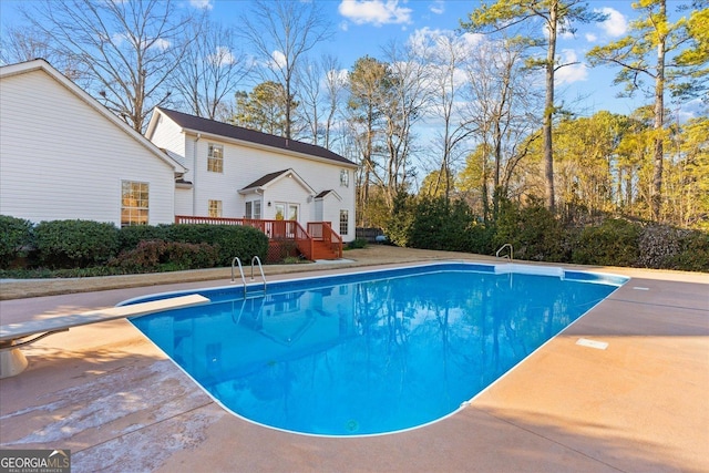 view of swimming pool with a diving board and a deck