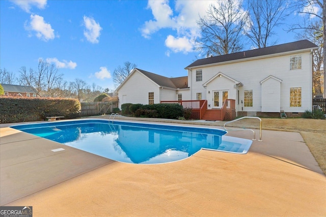 view of swimming pool featuring french doors, a deck, and a diving board