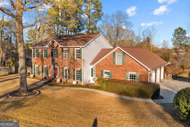 colonial-style house with a front yard and a garage