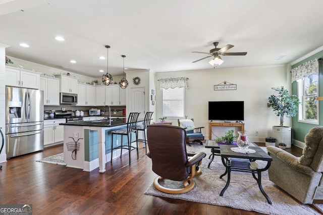 living room with ceiling fan, dark hardwood / wood-style floors, and ornamental molding