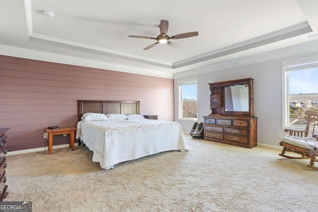 bedroom featuring light colored carpet, a raised ceiling, and ceiling fan