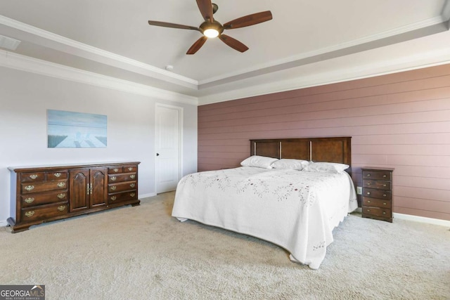 carpeted bedroom featuring a tray ceiling, ceiling fan, and crown molding