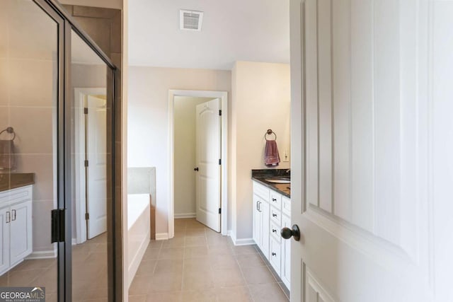 bathroom featuring tile patterned floors, vanity, and a tub