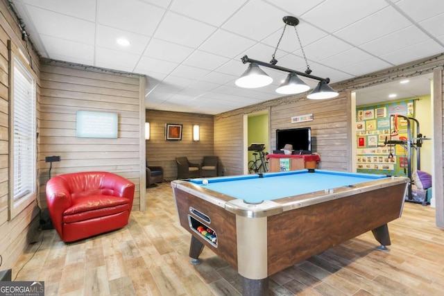 playroom featuring light wood-type flooring, a drop ceiling, wooden walls, and pool table