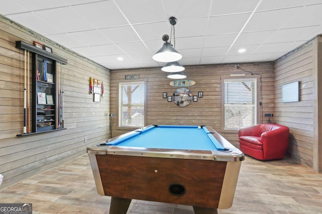 recreation room with a paneled ceiling, billiards, and wood walls