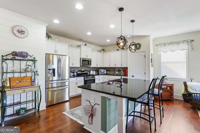 kitchen featuring sink, white cabinetry, stainless steel appliances, and an island with sink