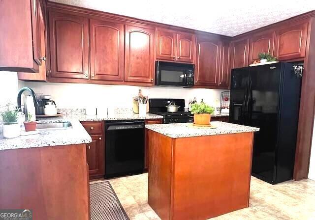 213 Moore Valley Way, Canton, GA 30115 - kitchen featuring black appliances, a sink, dark brown cabinets, a center island, and light stone counters