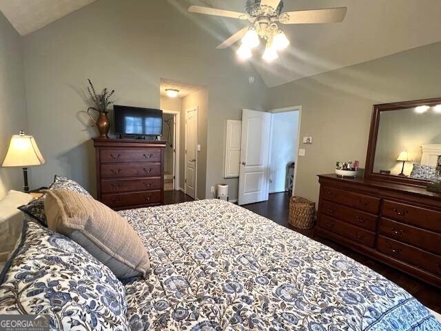 bedroom with dark wood-type flooring, ceiling fan, and vaulted ceiling