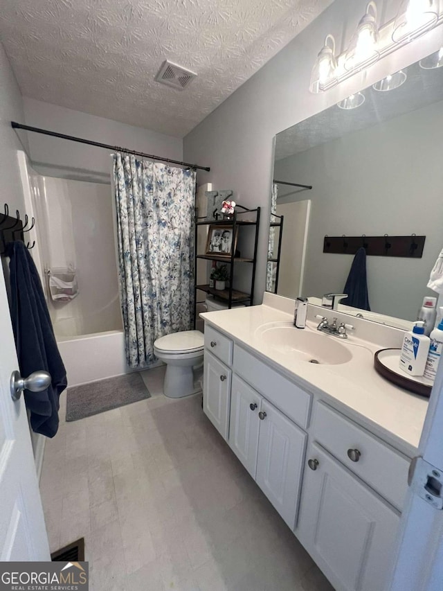 full bathroom featuring vanity, shower / bath combination with curtain, a textured ceiling, and toilet