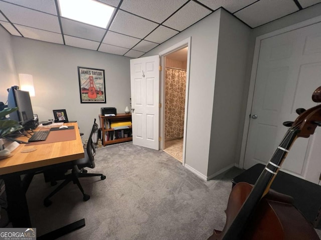 carpeted office space featuring a paneled ceiling