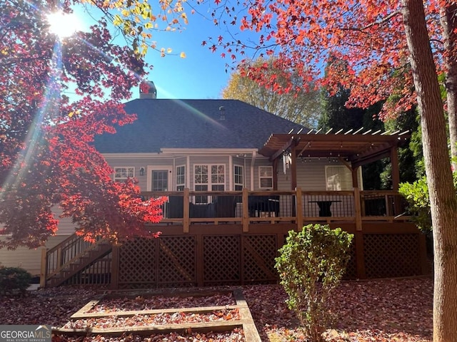 back of property with a wooden deck and a pergola