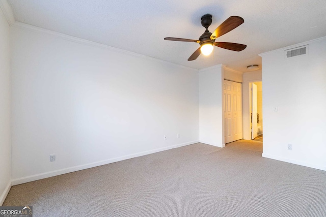 carpeted spare room with ornamental molding and ceiling fan