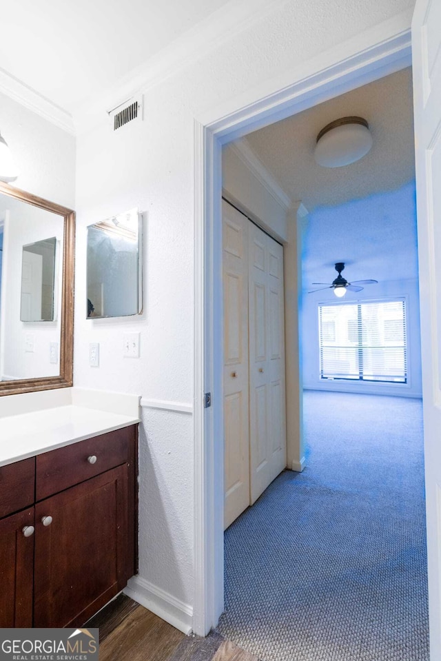 bathroom with ceiling fan, crown molding, and vanity