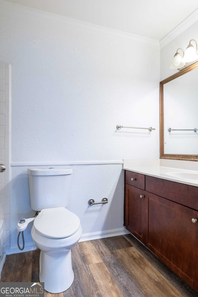 bathroom featuring hardwood / wood-style floors, crown molding, vanity, and toilet