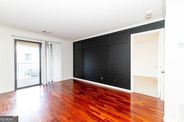 empty room with hardwood / wood-style flooring and ornamental molding