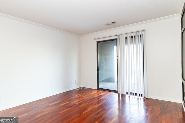 spare room featuring crown molding and dark wood-type flooring