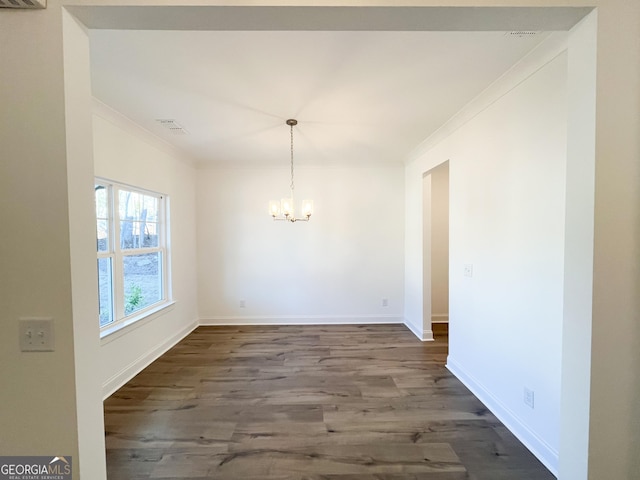 unfurnished dining area with dark hardwood / wood-style flooring, a notable chandelier, and ornamental molding