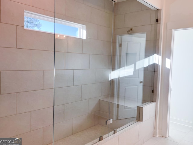 bathroom featuring tiled shower and tile patterned floors