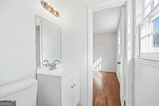 bathroom featuring vanity, hardwood / wood-style flooring, and toilet