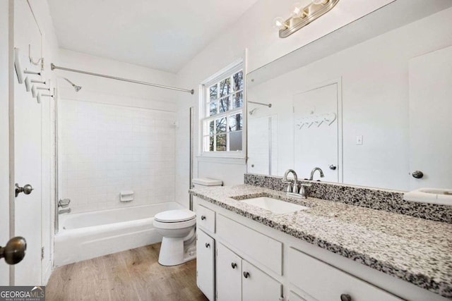 full bathroom with vanity, toilet, wood-type flooring, and tiled shower / bath