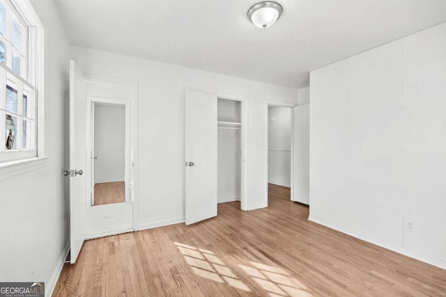 unfurnished bedroom featuring light hardwood / wood-style flooring and multiple windows