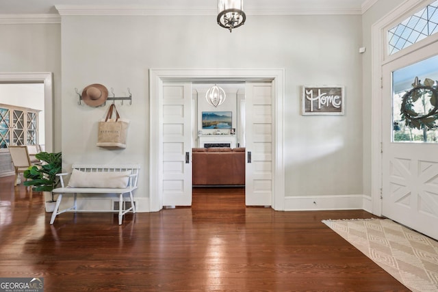 foyer featuring ornamental molding, dark hardwood / wood-style floors, and a notable chandelier