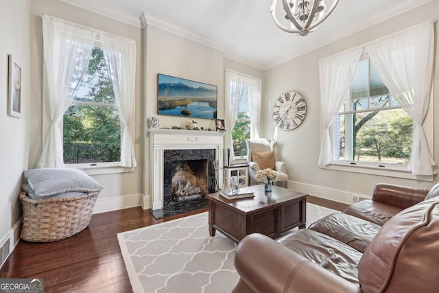 living room featuring a healthy amount of sunlight, a premium fireplace, dark wood-type flooring, and ornamental molding