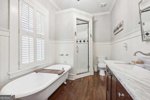 full bathroom featuring toilet, wood-type flooring, crown molding, and independent shower and bath