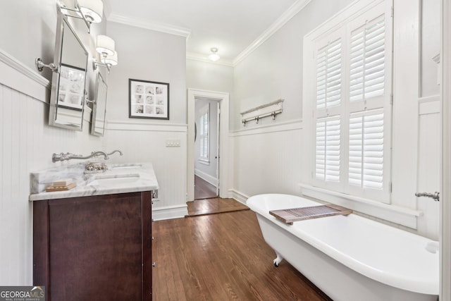 bathroom with crown molding, a bathtub, vanity, and hardwood / wood-style flooring