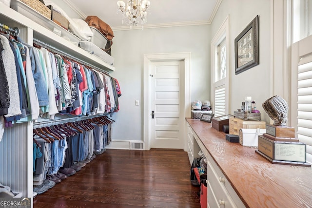 spacious closet featuring dark hardwood / wood-style flooring and a notable chandelier