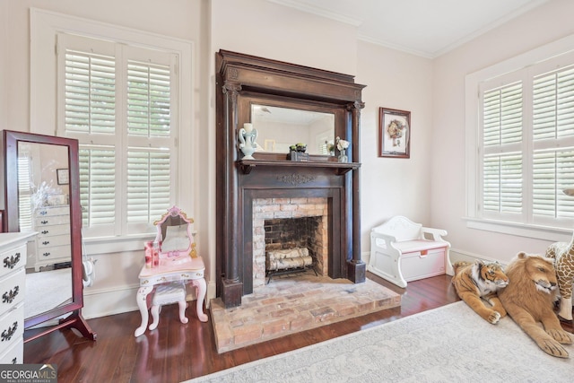 living area with a fireplace, dark hardwood / wood-style flooring, and crown molding