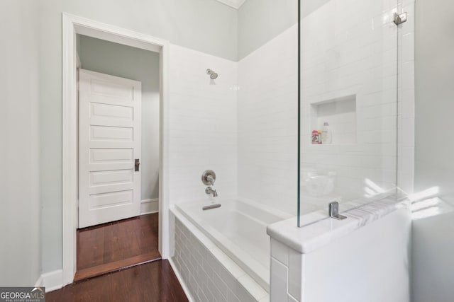 bathroom with hardwood / wood-style floors and tiled shower / bath