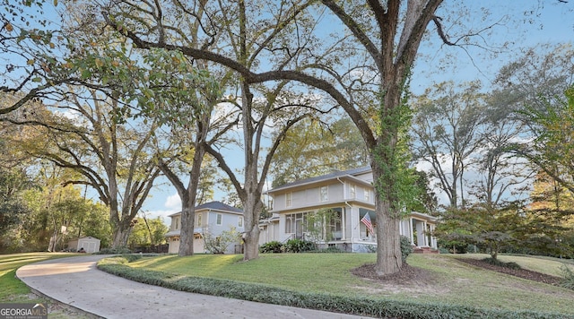 view of front of house with a storage shed, a front lawn, and a garage