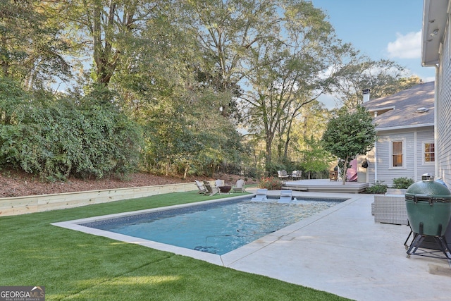 view of swimming pool featuring a yard and a patio area