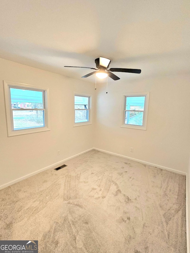 carpeted spare room featuring ceiling fan