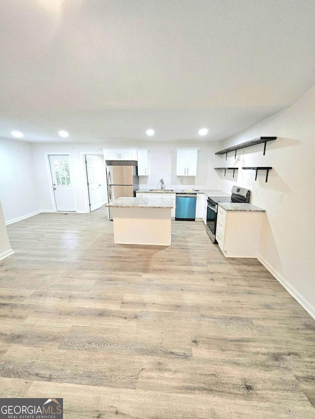 kitchen featuring decorative backsplash, appliances with stainless steel finishes, sink, light hardwood / wood-style flooring, and white cabinetry