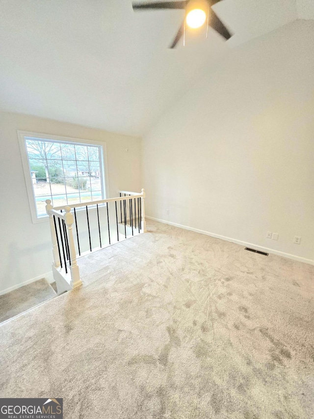 unfurnished room featuring lofted ceiling and carpet