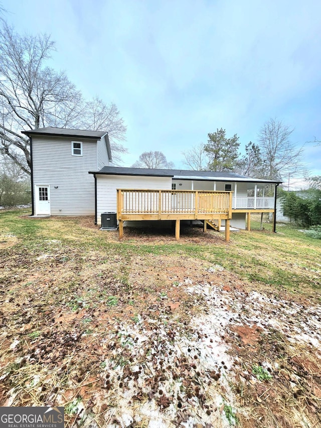 rear view of property featuring central AC, a yard, and a wooden deck